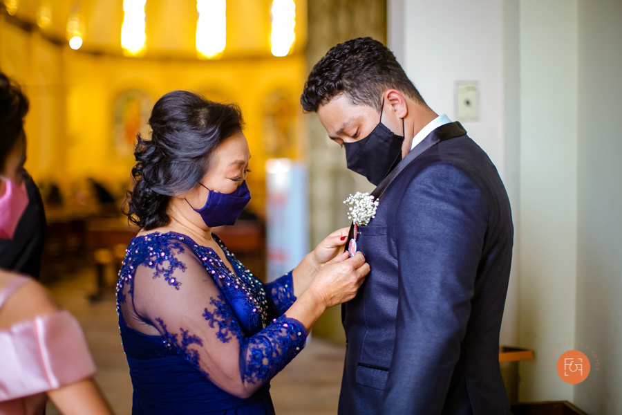 mãe arrumando gravata do noivo na igreja