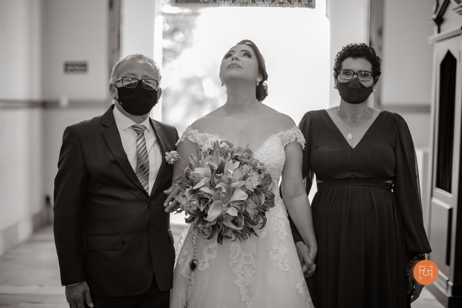 noiva se preparando para entrar na igreja com os pais