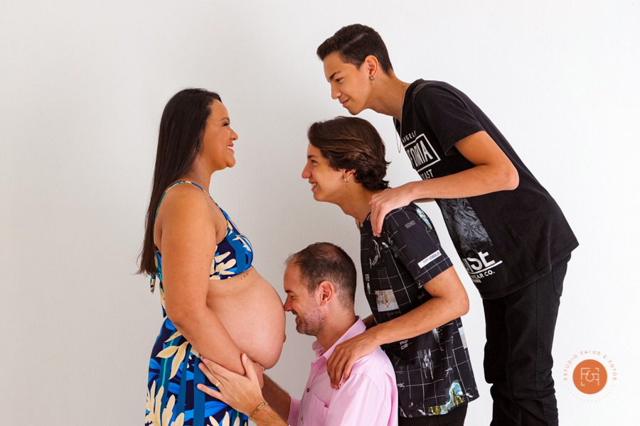 gestante com o papai e os filhos com a mão na barriga