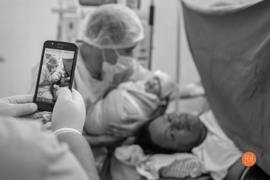 enfermeira tirando foto, da mamãe com o papai e a bebe, com o celular 