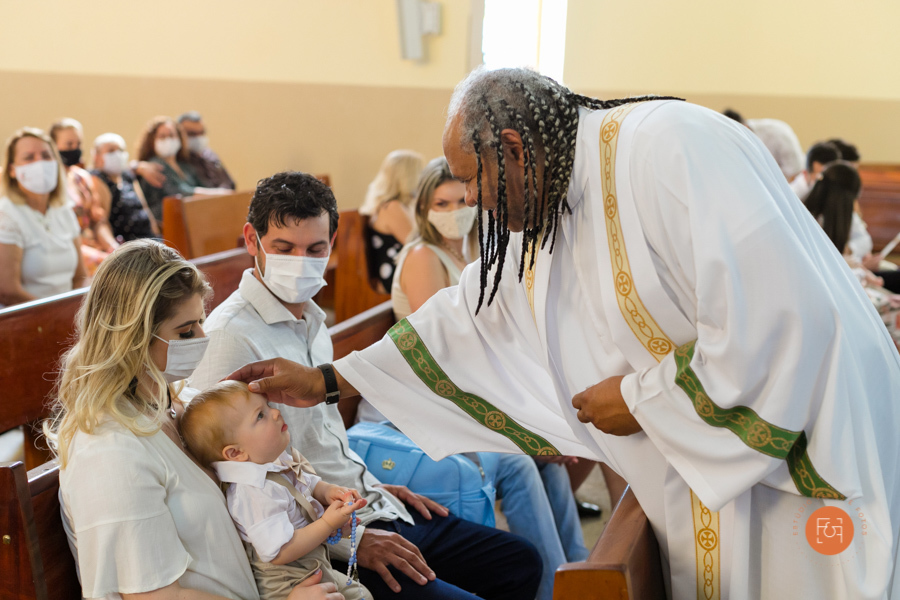padre dando a benção no batizado