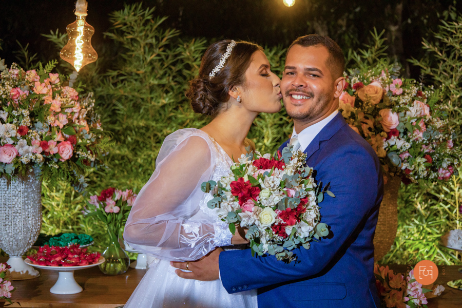 noiva dando um beijo na bochecha do noivo