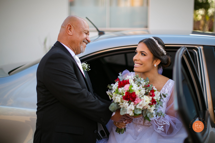 noiva descendo do carro com a ajuda do pai