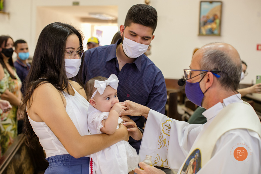 bebe recebendo a benção do padre no batizado