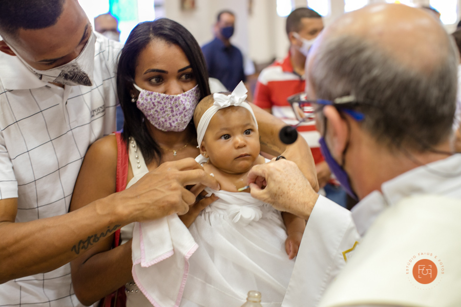 bebe recebendo a benção do padre no batizado