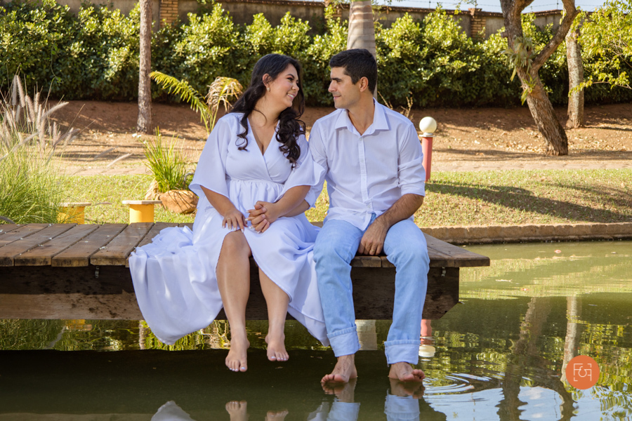 casal sentado na beira do lago