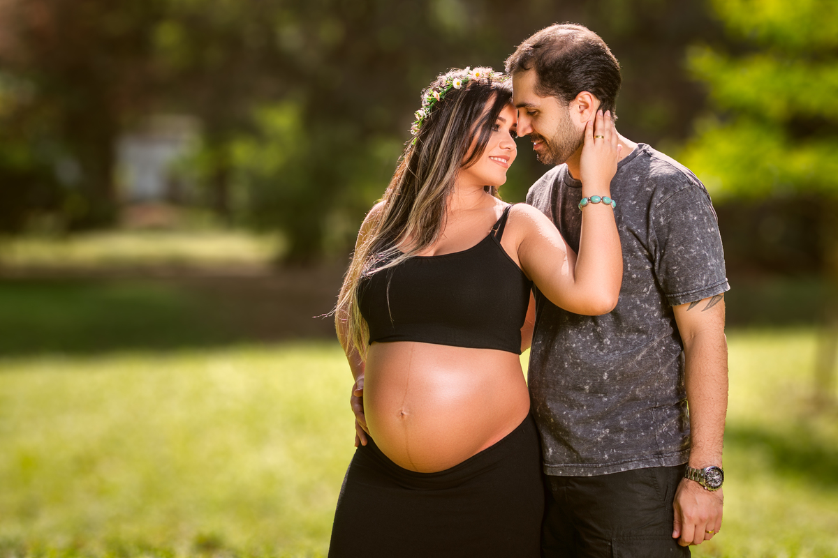 Book gestante, grávida com saia e croped preto fazendo carinho no marido no Jardim Botanico do Rio de Janeiro