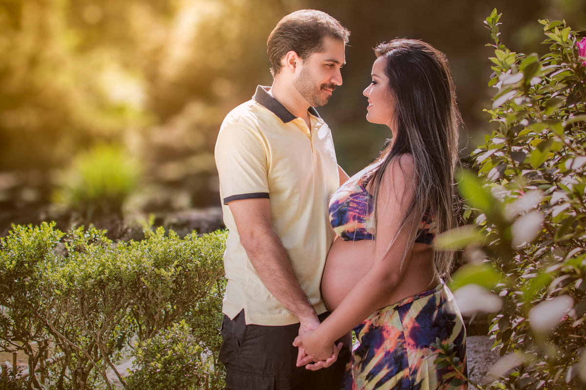 casal se olhando durante ensaio gestante no jardim botanico do rio de janeiro com luz perfeita.