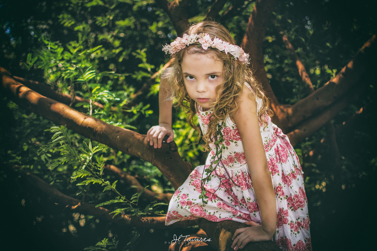 foto do ensaio infantil da Isabela, vestindo vestido branco, uma tiara de flores e descalça!