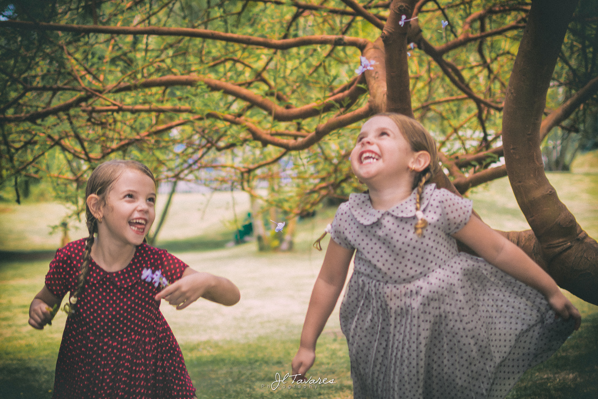crianças de vestido estampado pulando, próximo a árvores do park rio 2.