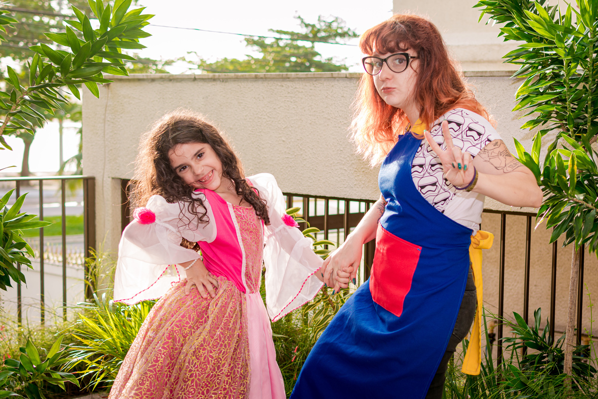 Animadora da festa no jardim junto com a irmã do aniversariante