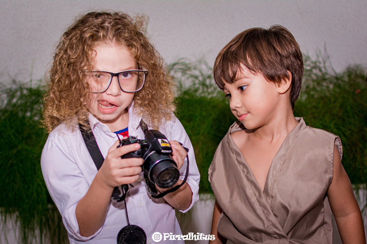 Matheus e amigo da escola que estava fantasiado de Peter Park segurando uma camera fotográfica na mão.