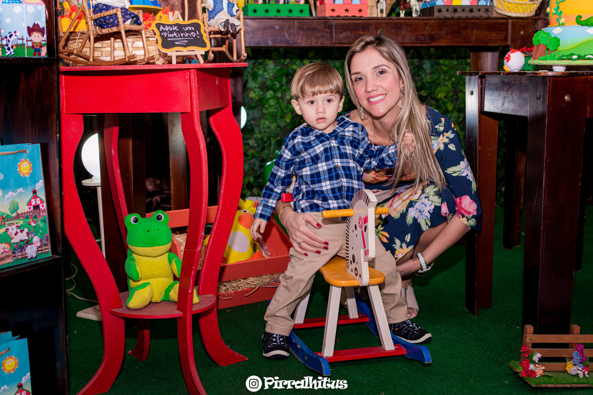 mãe abraçada ao filho sentado num cavalinho de pau. Cobertura Fotográfica de Festa Infantil do Gabriel, 2 aninhos.