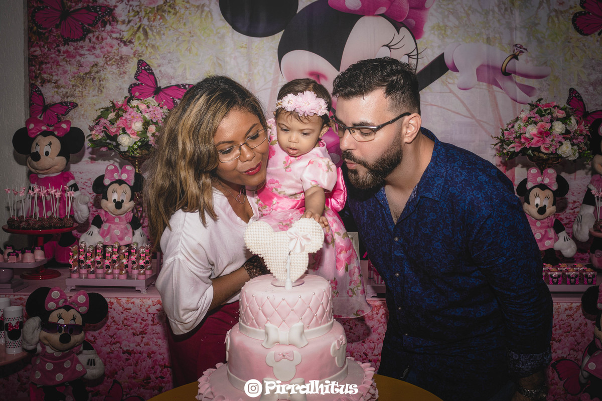 Família assoprando a vela do bolo na hora do parabéns. Fotografia de festa infantil Pirralhitus.