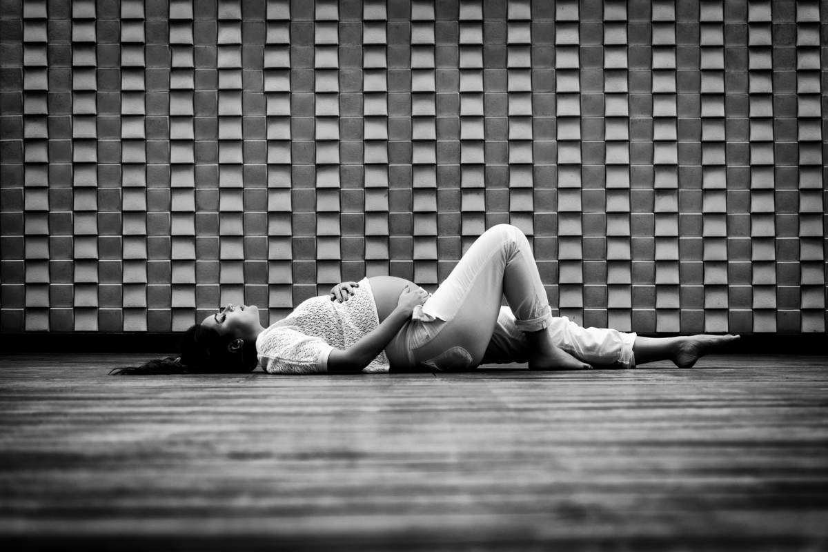 Grávida deitada no deck da piscina