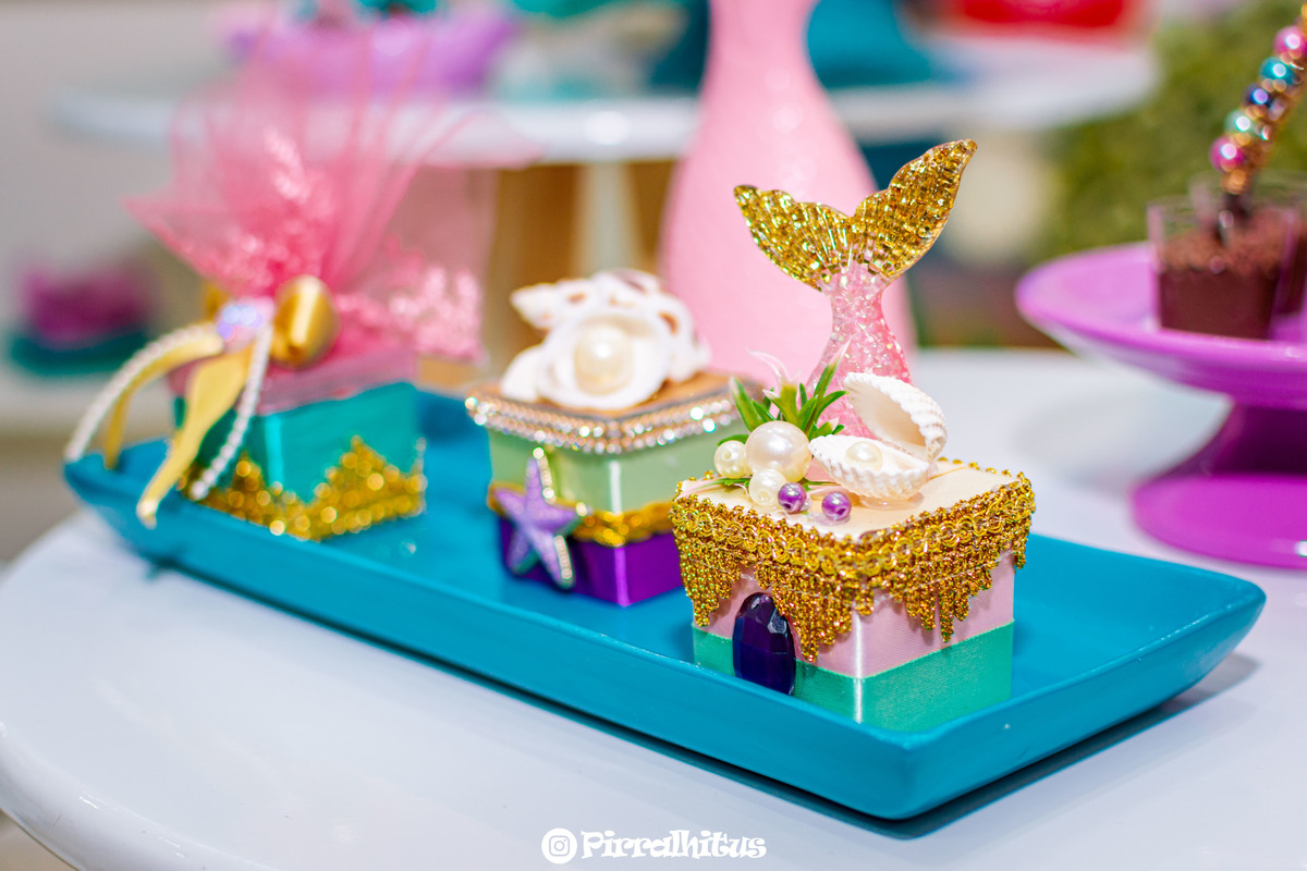 Caixinhas decorativas na mesa do bolo.