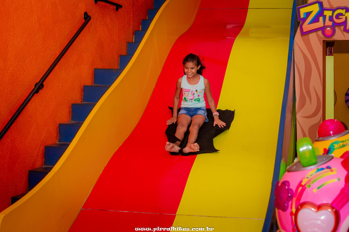 criança descendo no tobogam da casa de festas zigboom