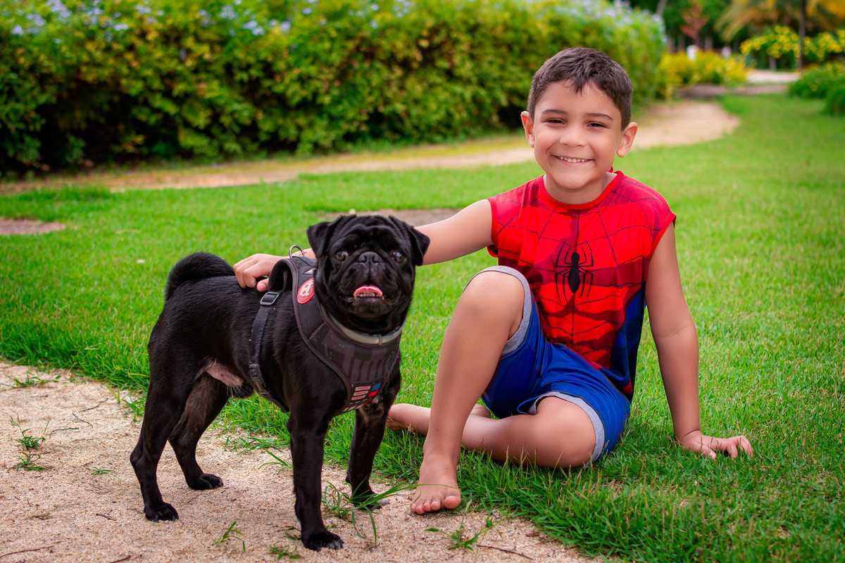 Menino com um bulldog frances no Rio 2 Park.