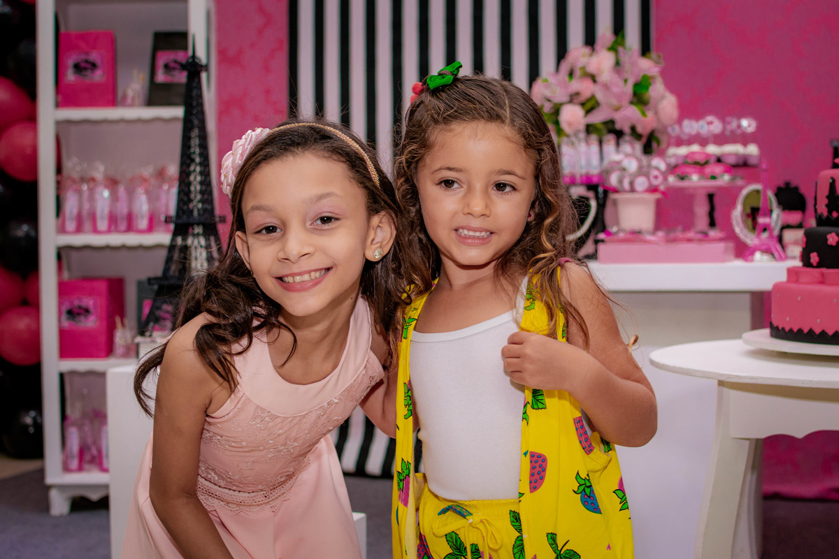 aniversariante e amiga na mesa do bolo.