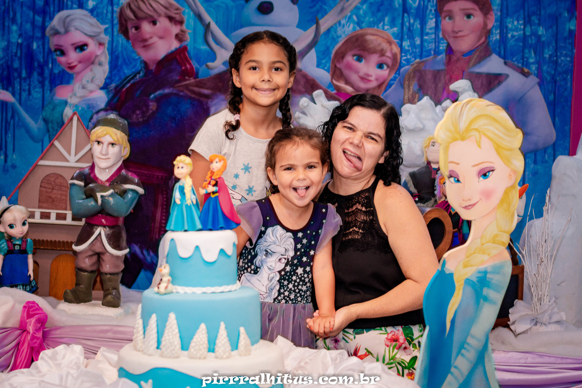 família na mesa do bolo de aniversário. Festa tema Frozan.
