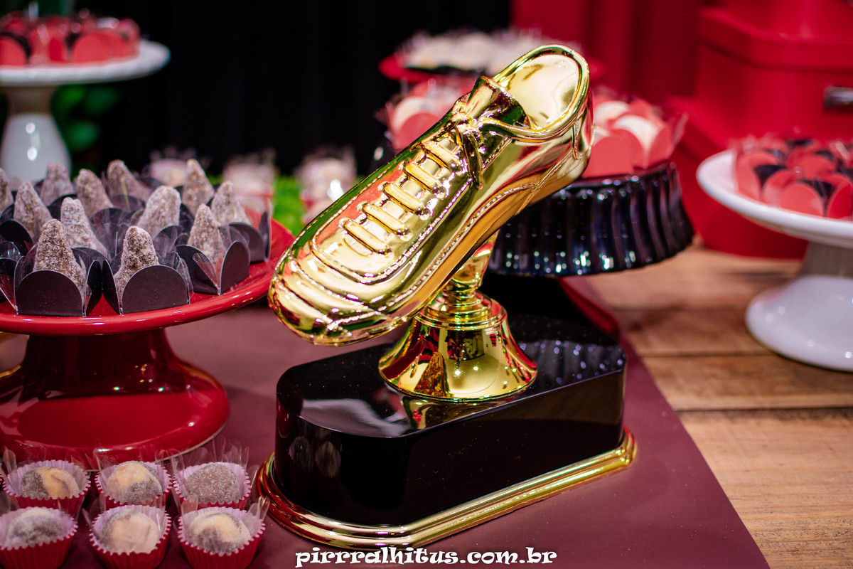 Troféu chuteira de ouro, ornamentando a mesa do bolo. Tema Flamengo.