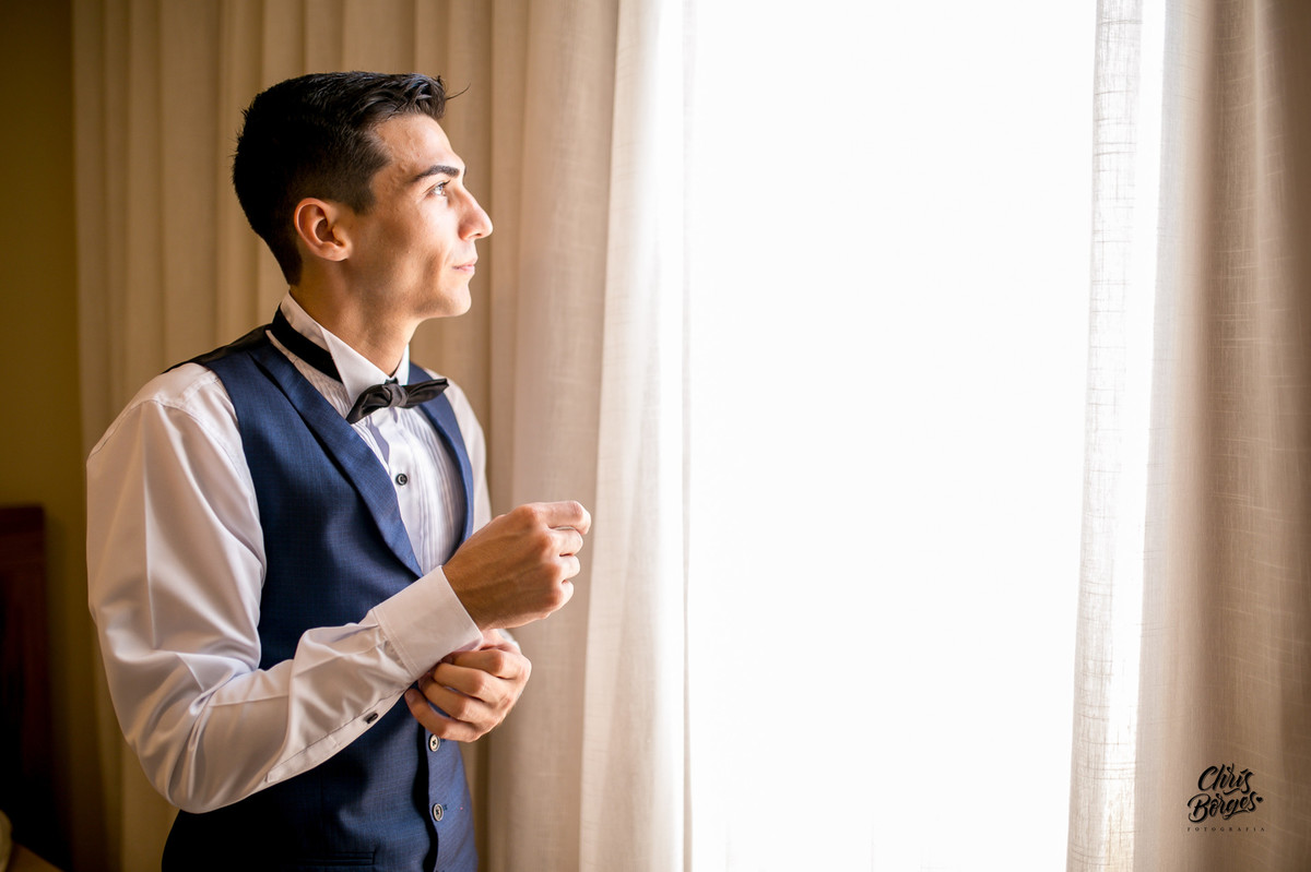 noivo se arrumando na janela