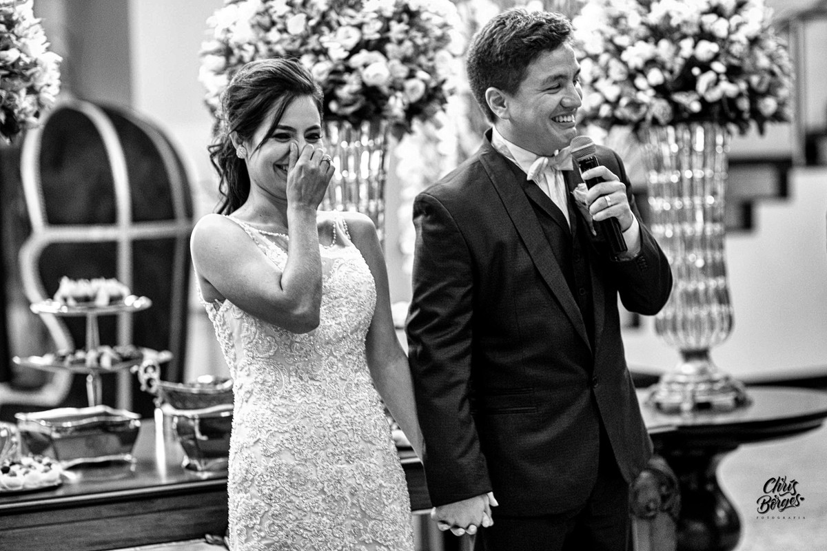 noivos sorrindo ao falar no microfone