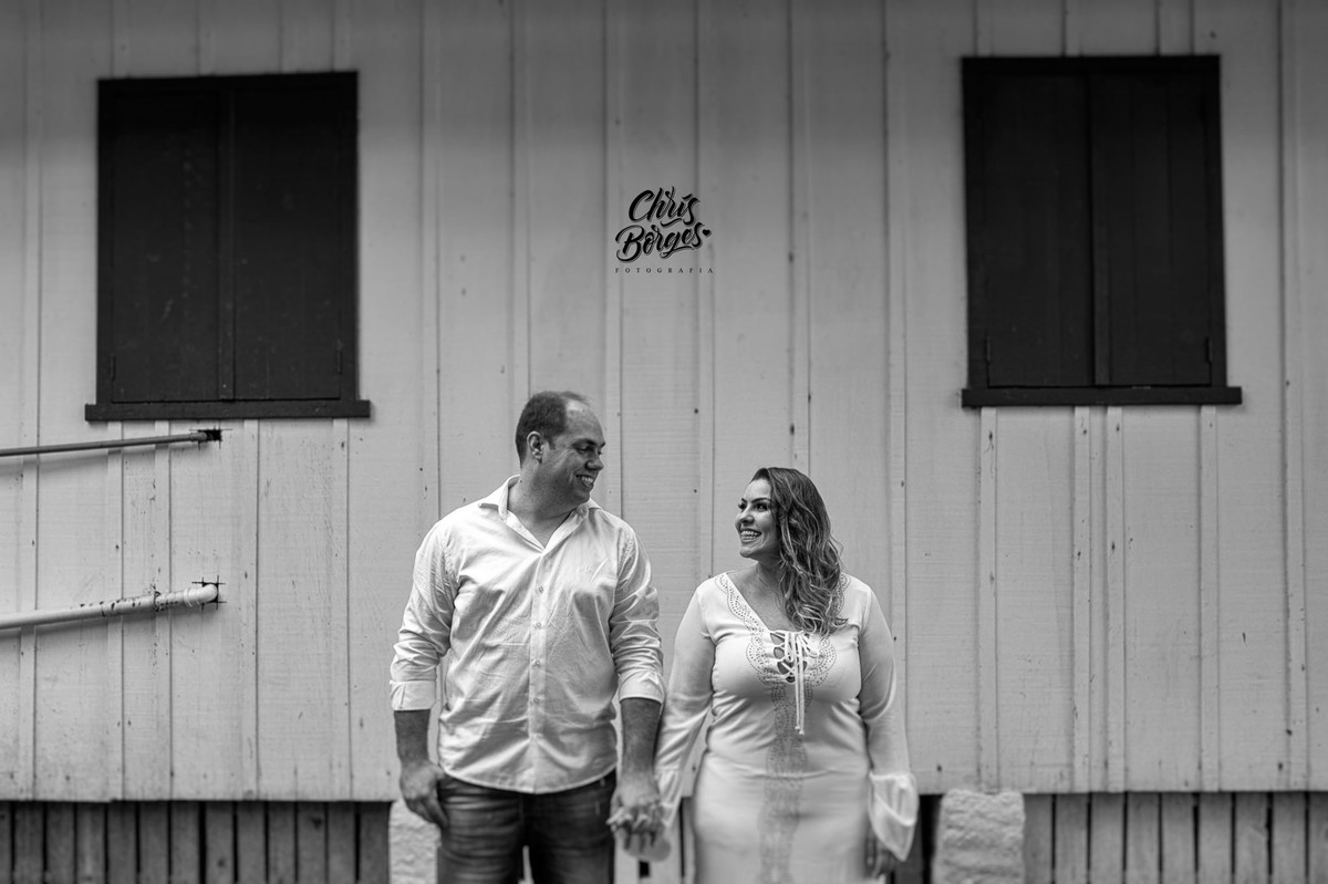 noivos posando em frente a casa de madeira