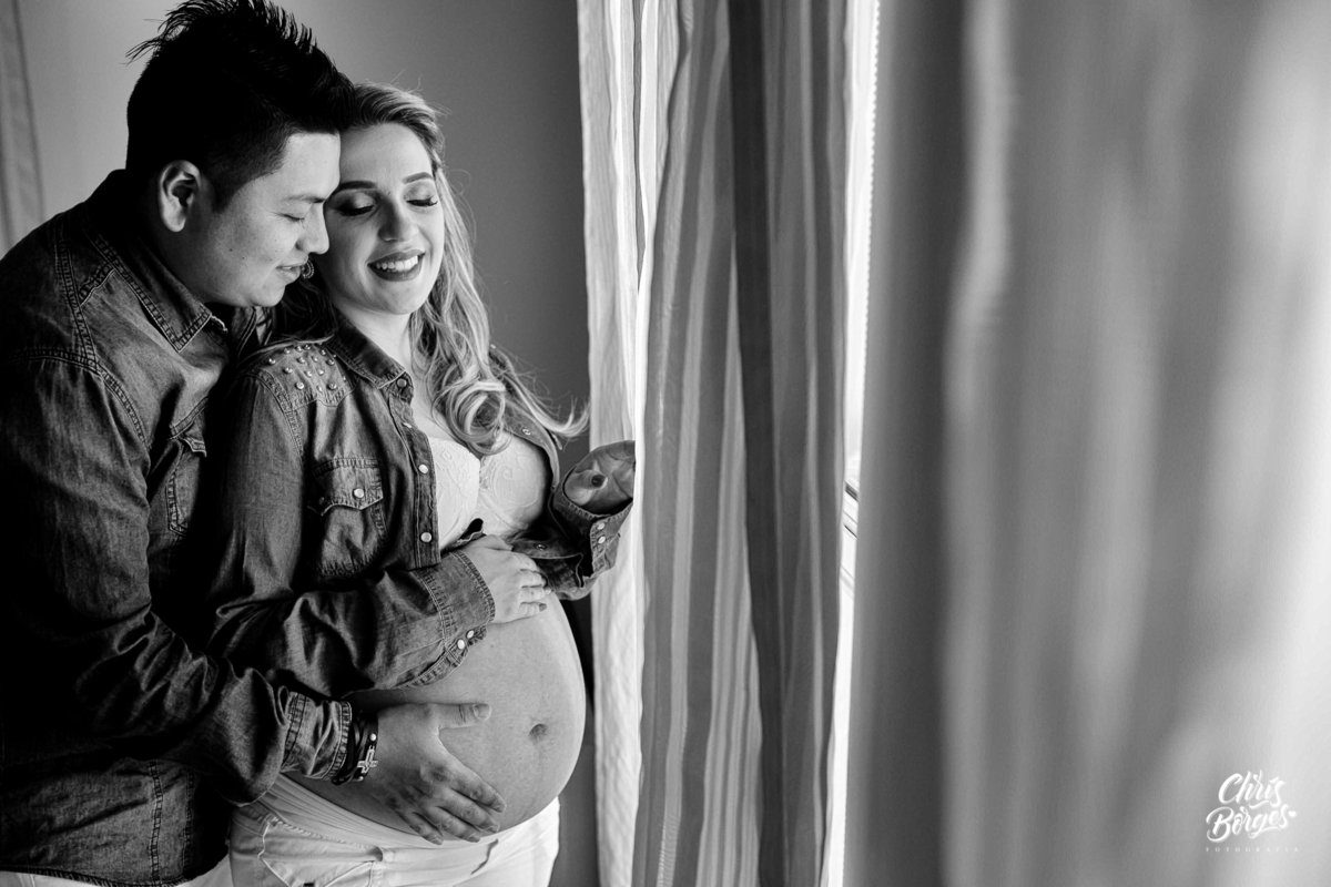 Mamãe e papai trocando carinhos juntos à janela