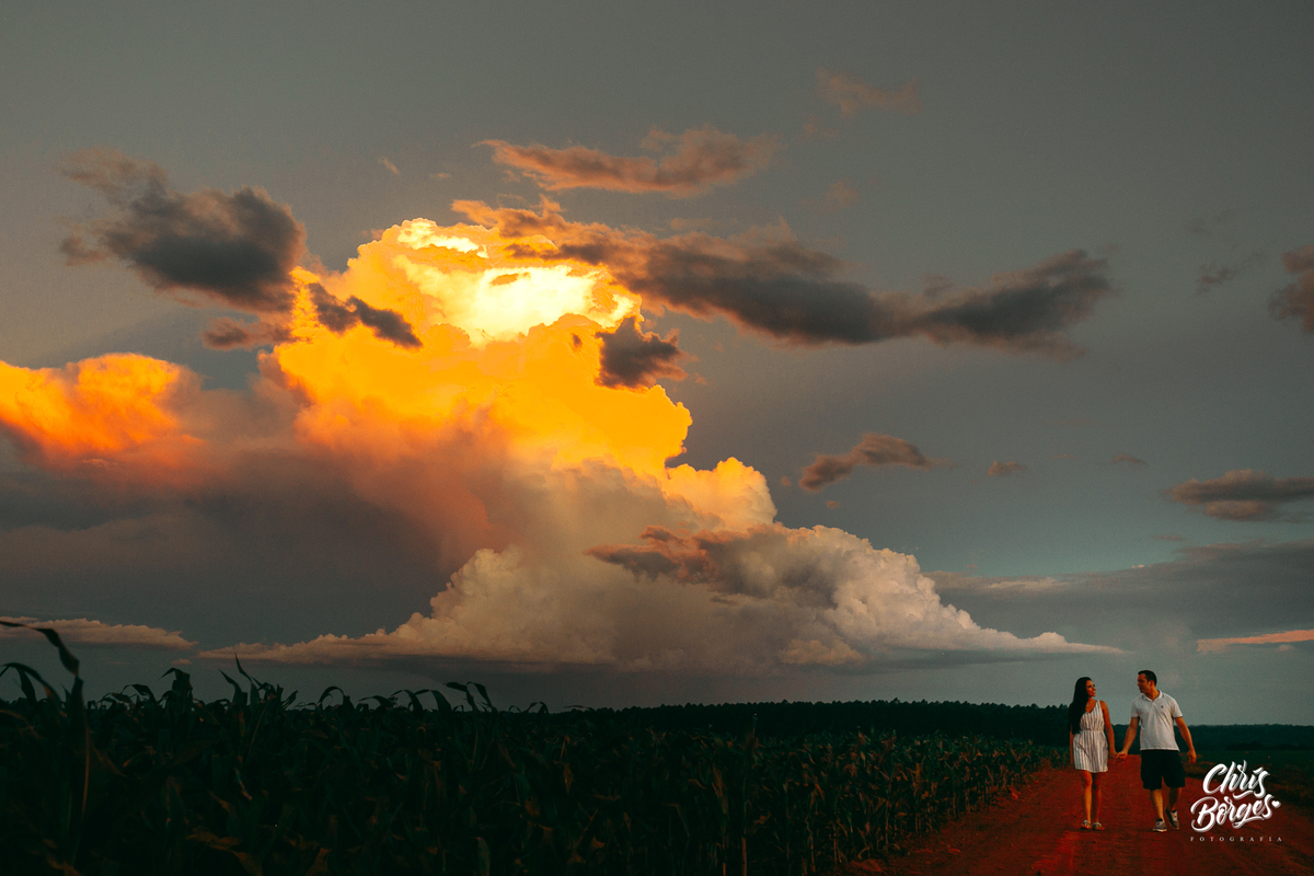Noivos passeando de mãos dadas no por do sol