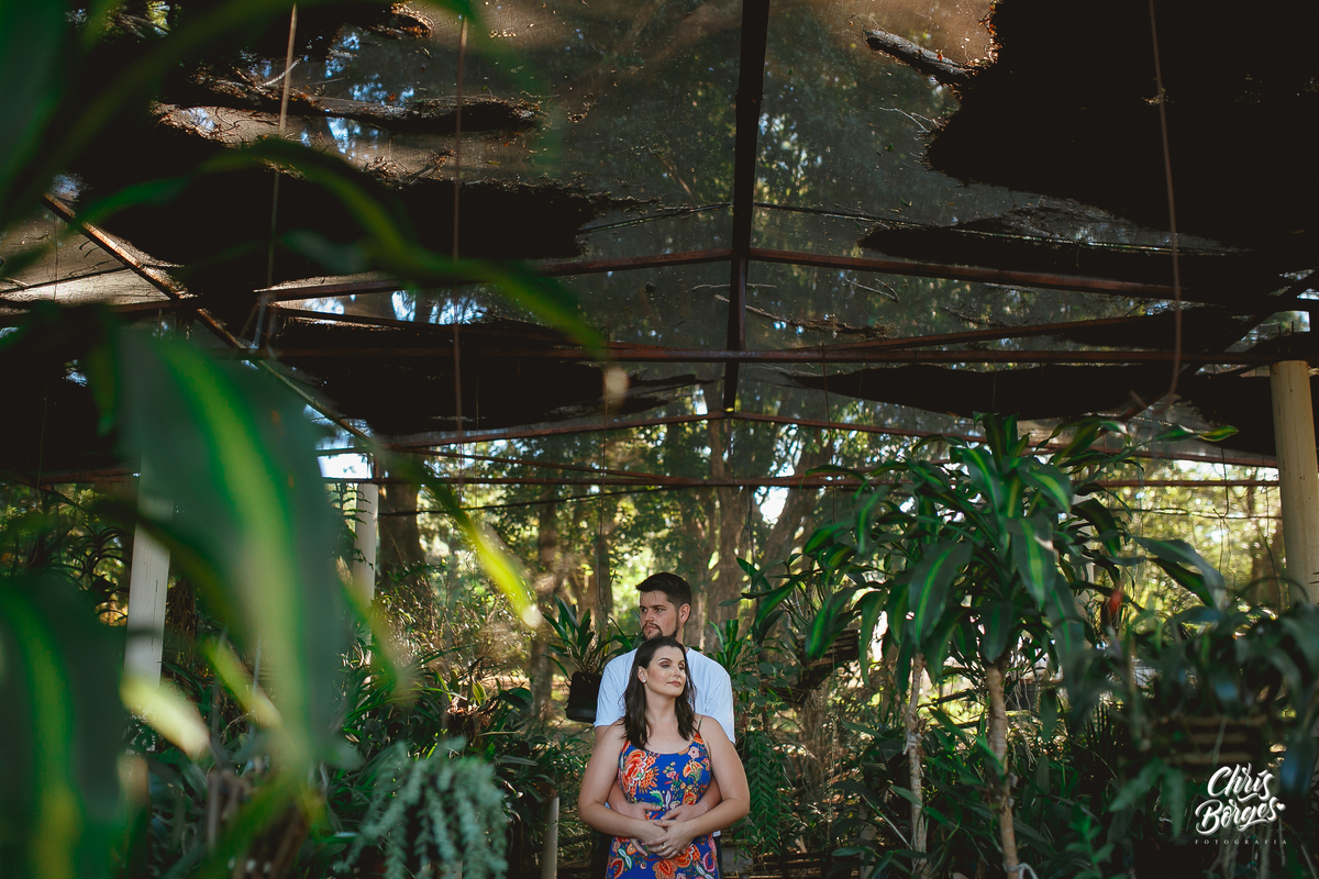 noivos abraçados em meio às plantas