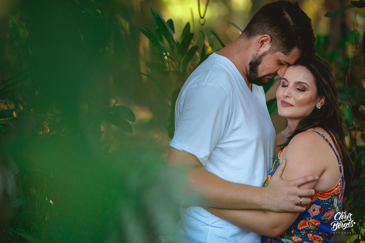 noivos abraçados em meio às plantas