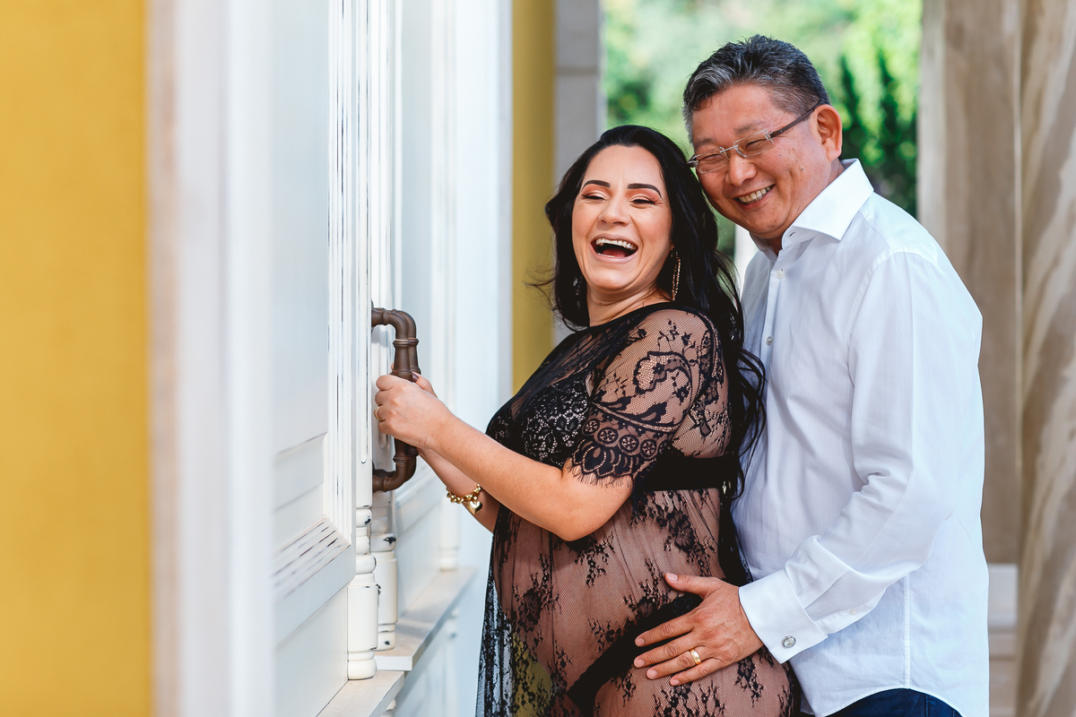 Marido e gestante dando gargalhadas