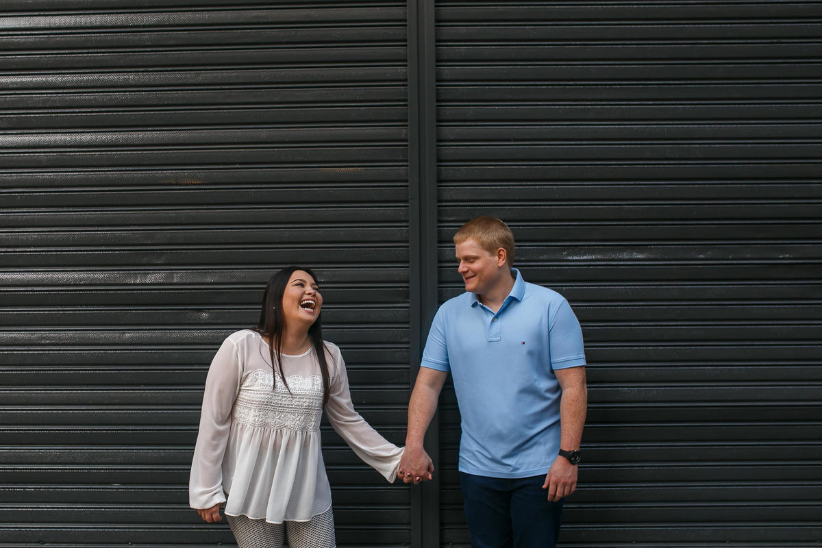 casal de mãos dadas e sorrindo em frente a porta