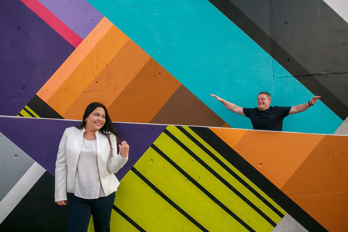 noiva divando e noivo pulando pra chamar a atenção em muros coloridos