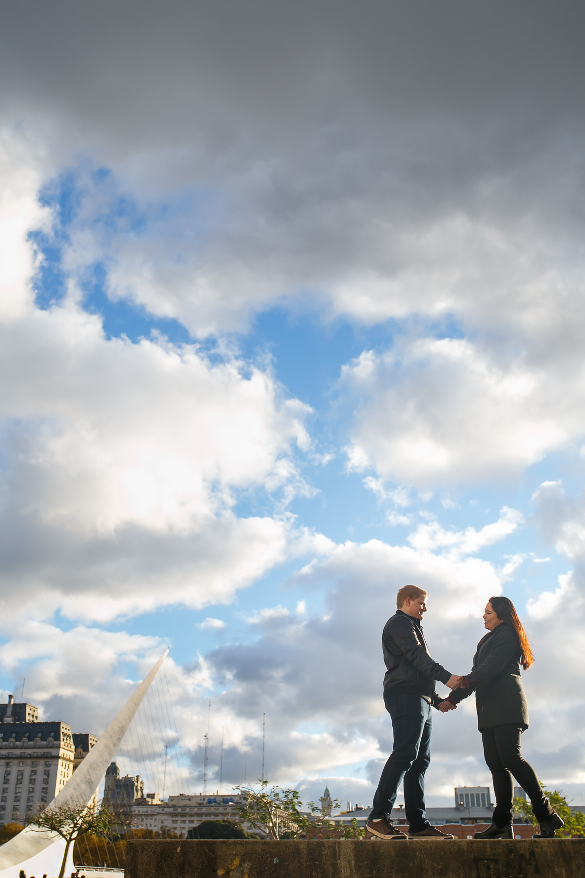noivos namorando sobre mureta
