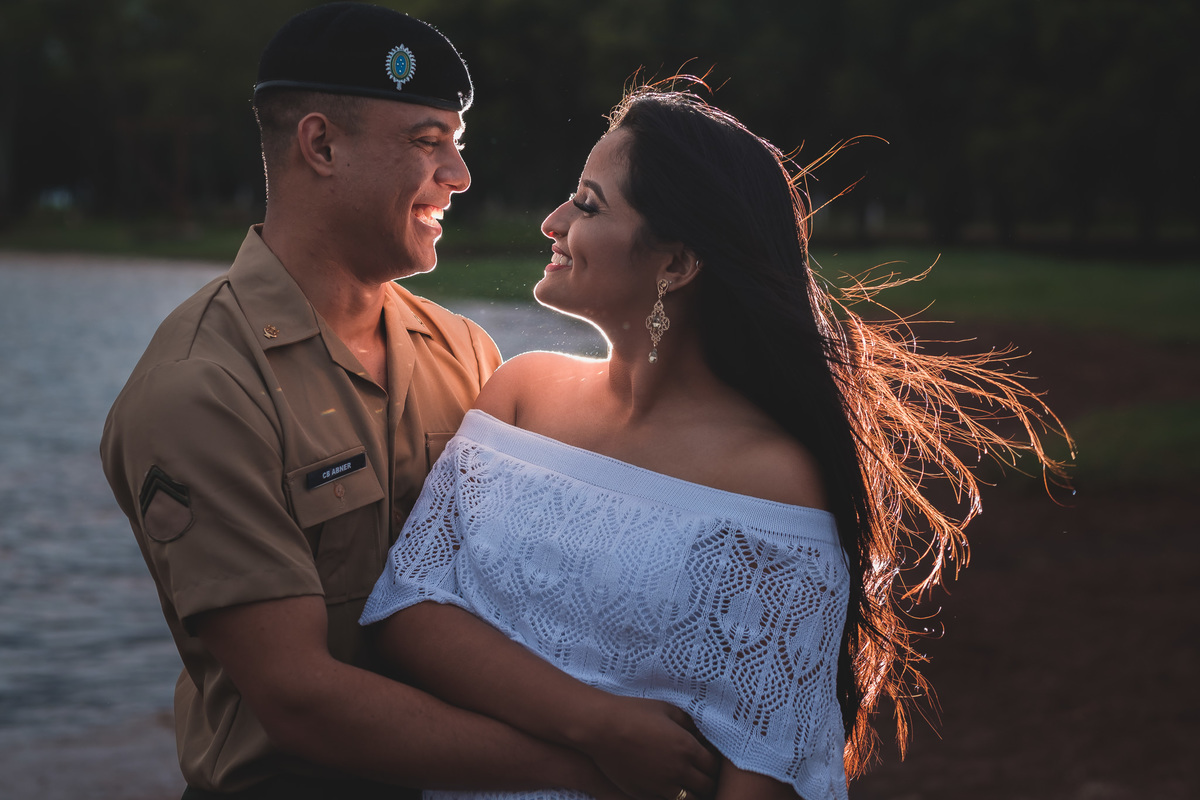 noivos felizes e sorridentes abraçados na beira do lago