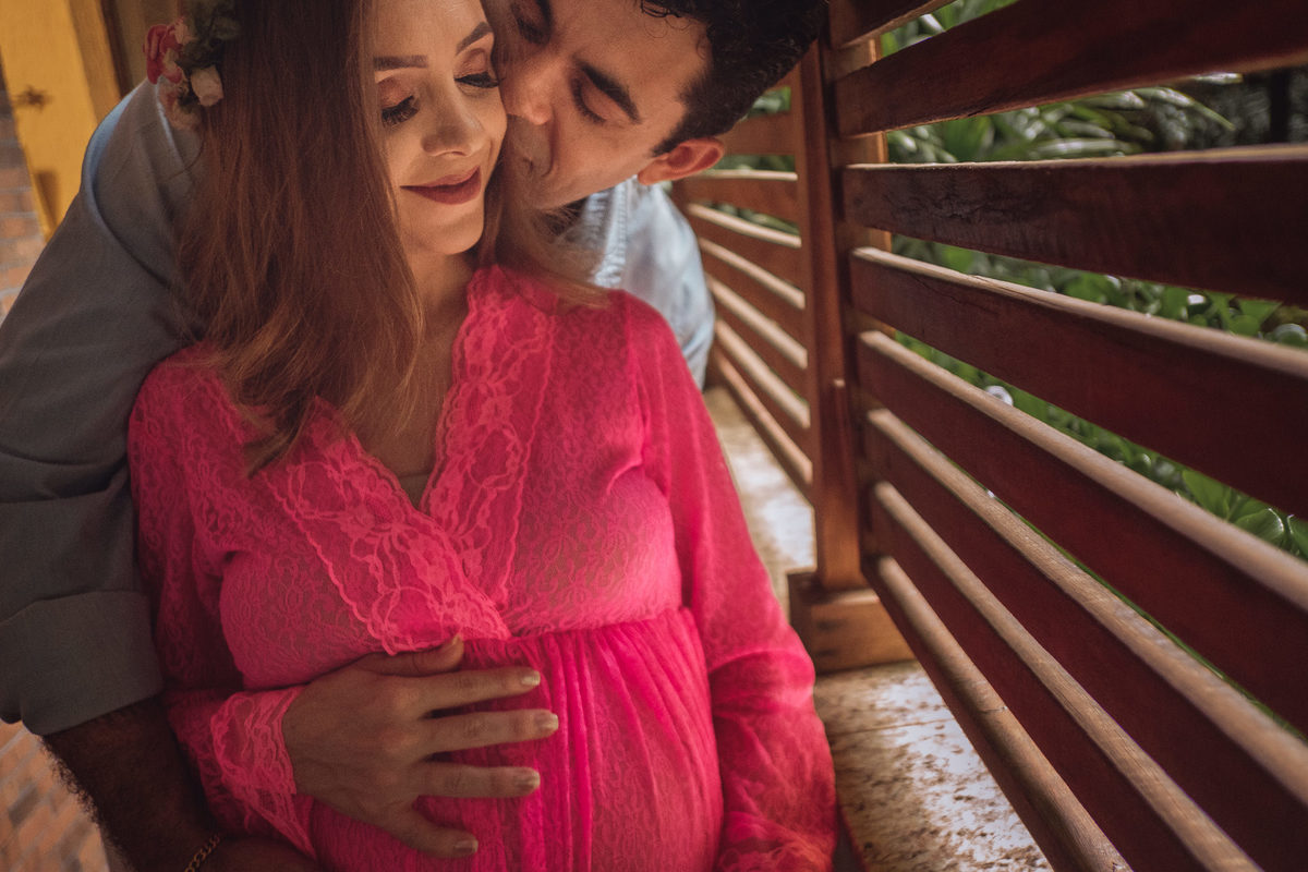 mamãe gestante sendo abraçada e beijada pelo papai