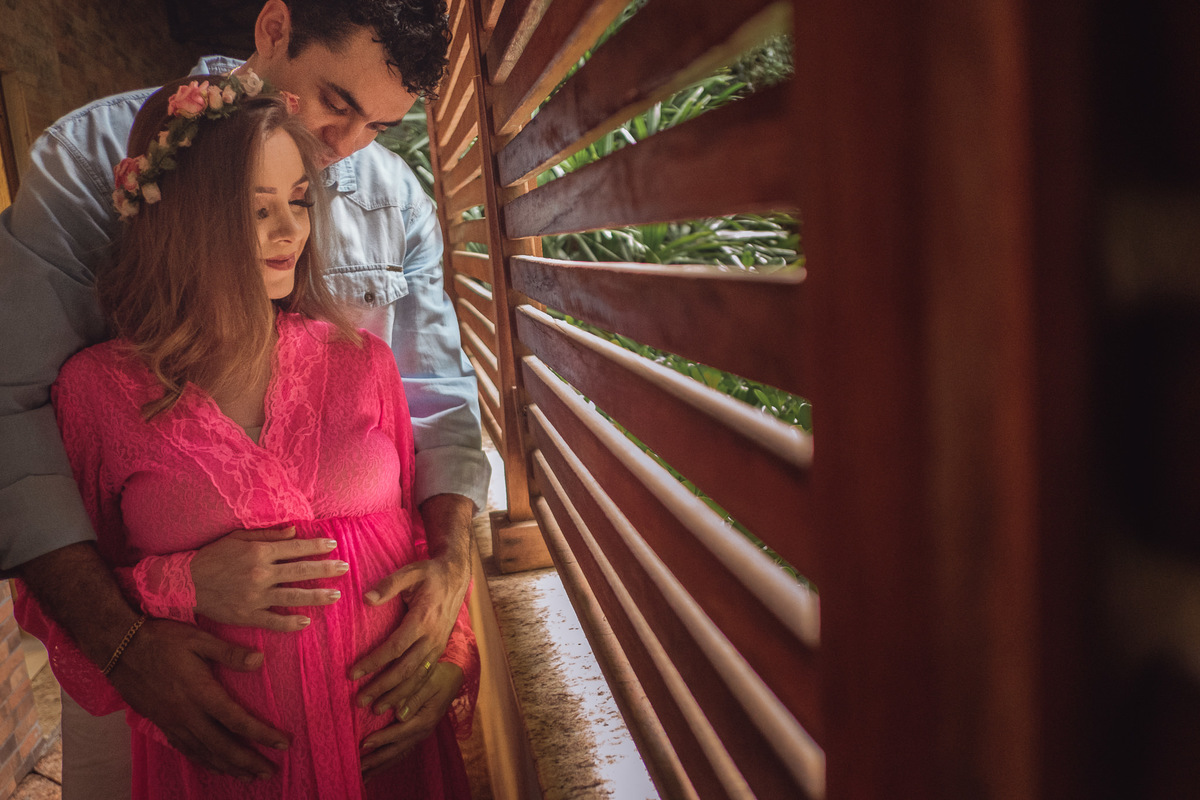 mamãe gestante sendo abraçada e protegida pelo papai