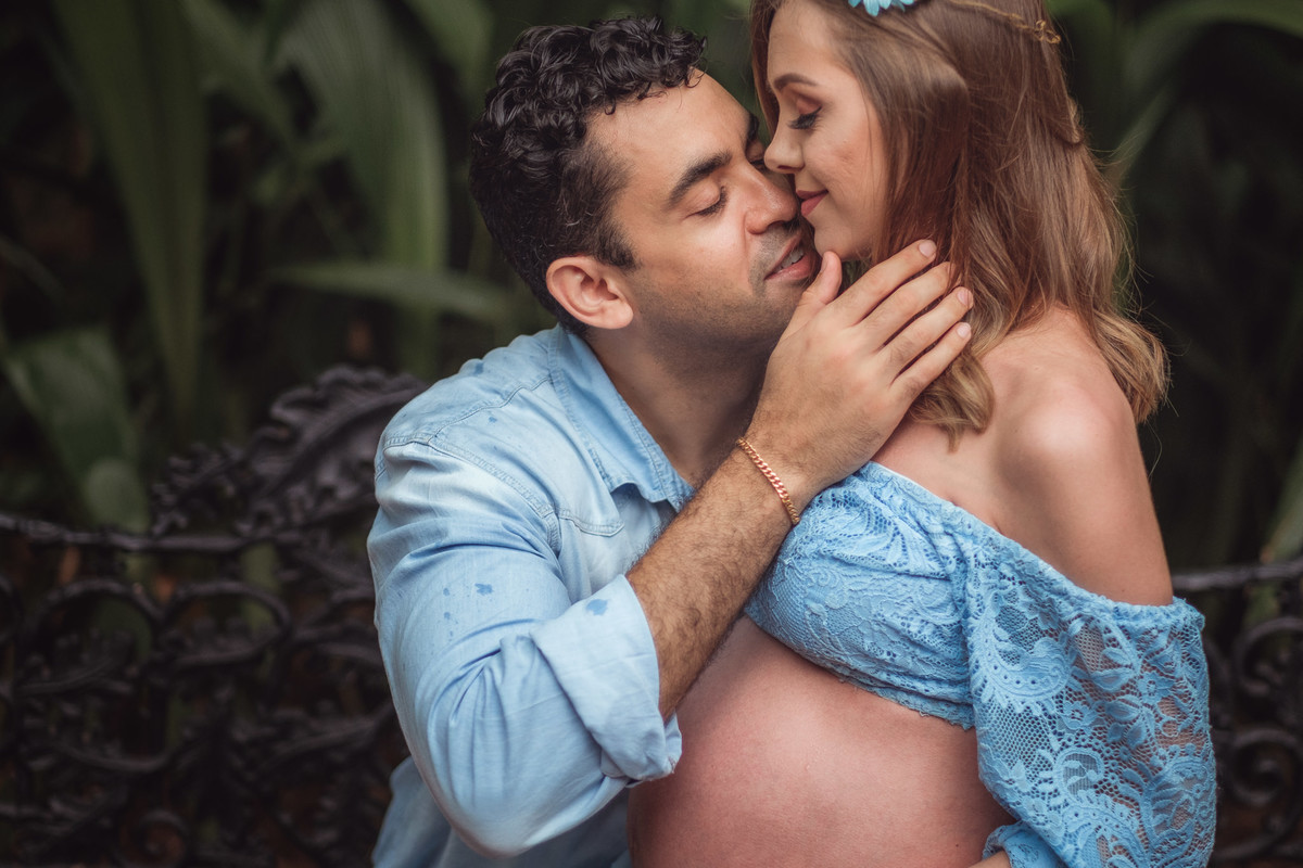 mamãe gestante sentada no colo do papai 