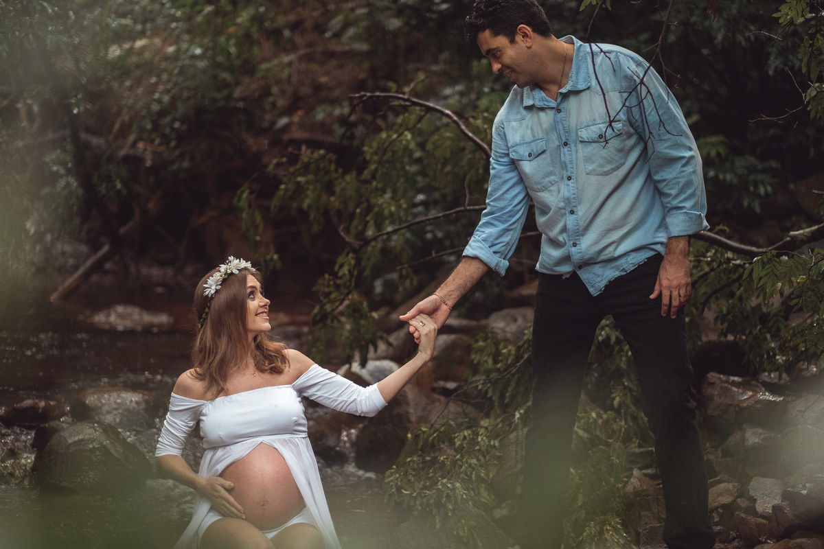 Mamãe gestante tendo ajuda do papai para se levantar