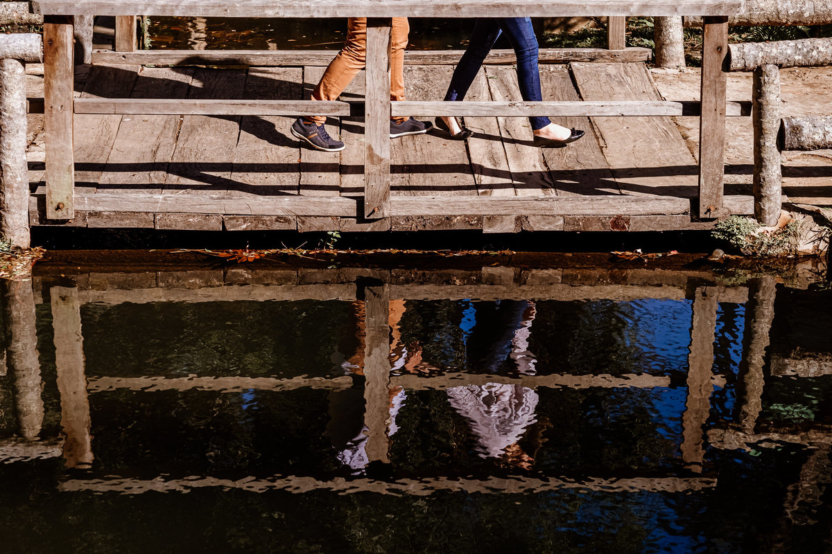 pernas dos noivos caminhando sobre a ponte