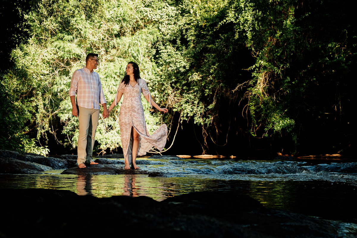 noivos caminhando sobre pedras no rio