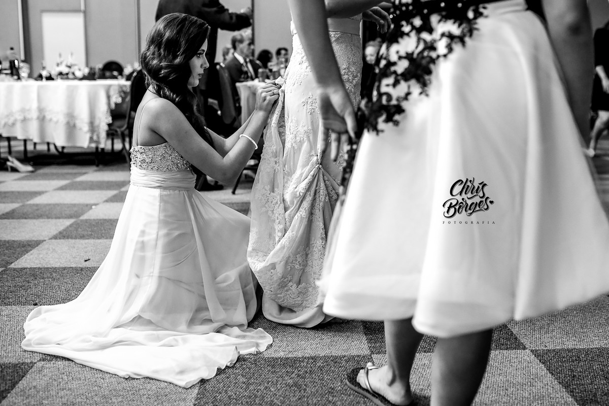 filha arrumando o vestido da noiva