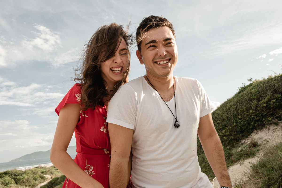 noivos sorrindo no ensaio precasamento na praia