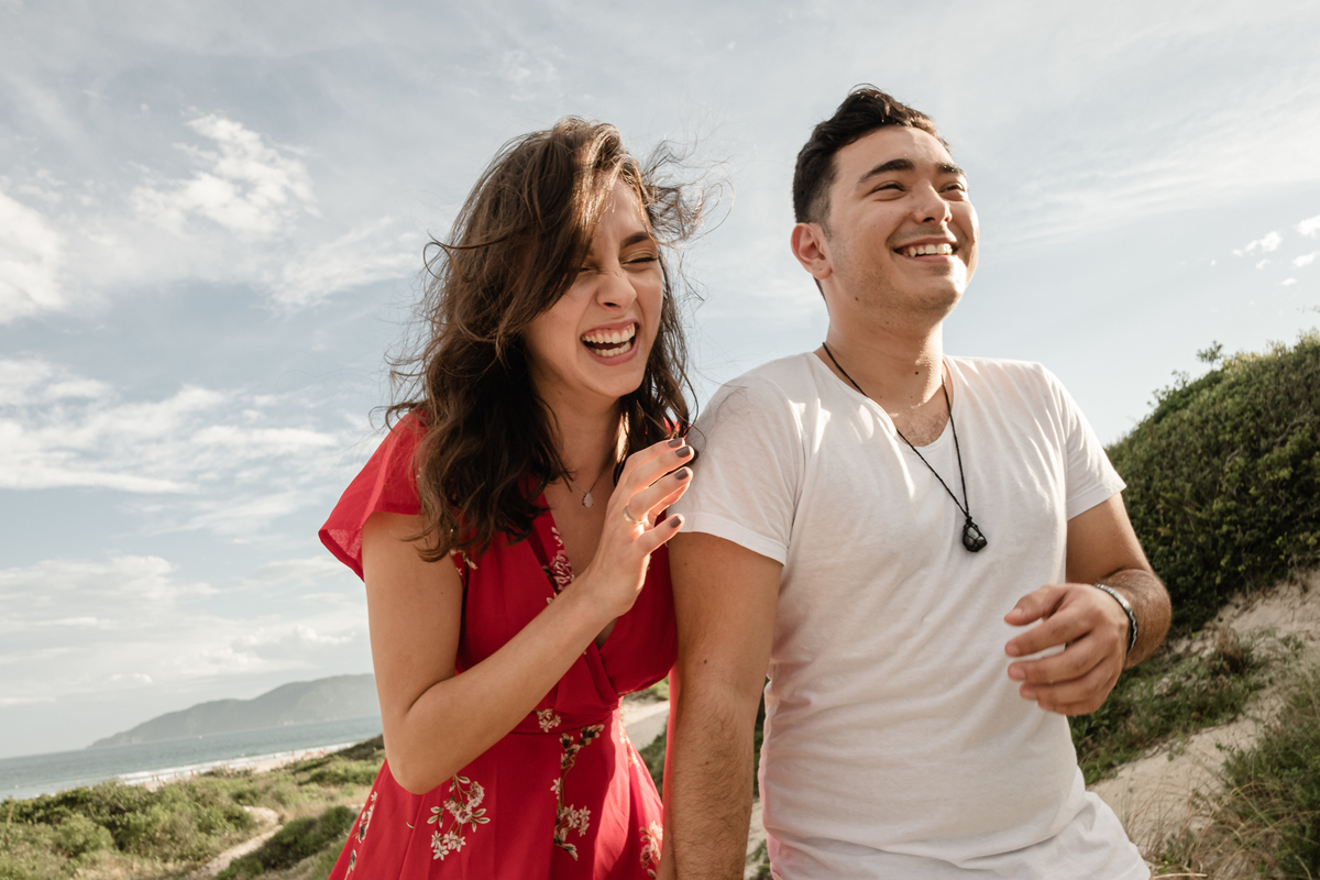 noivos sorrindo no ensaio precasamento na praia