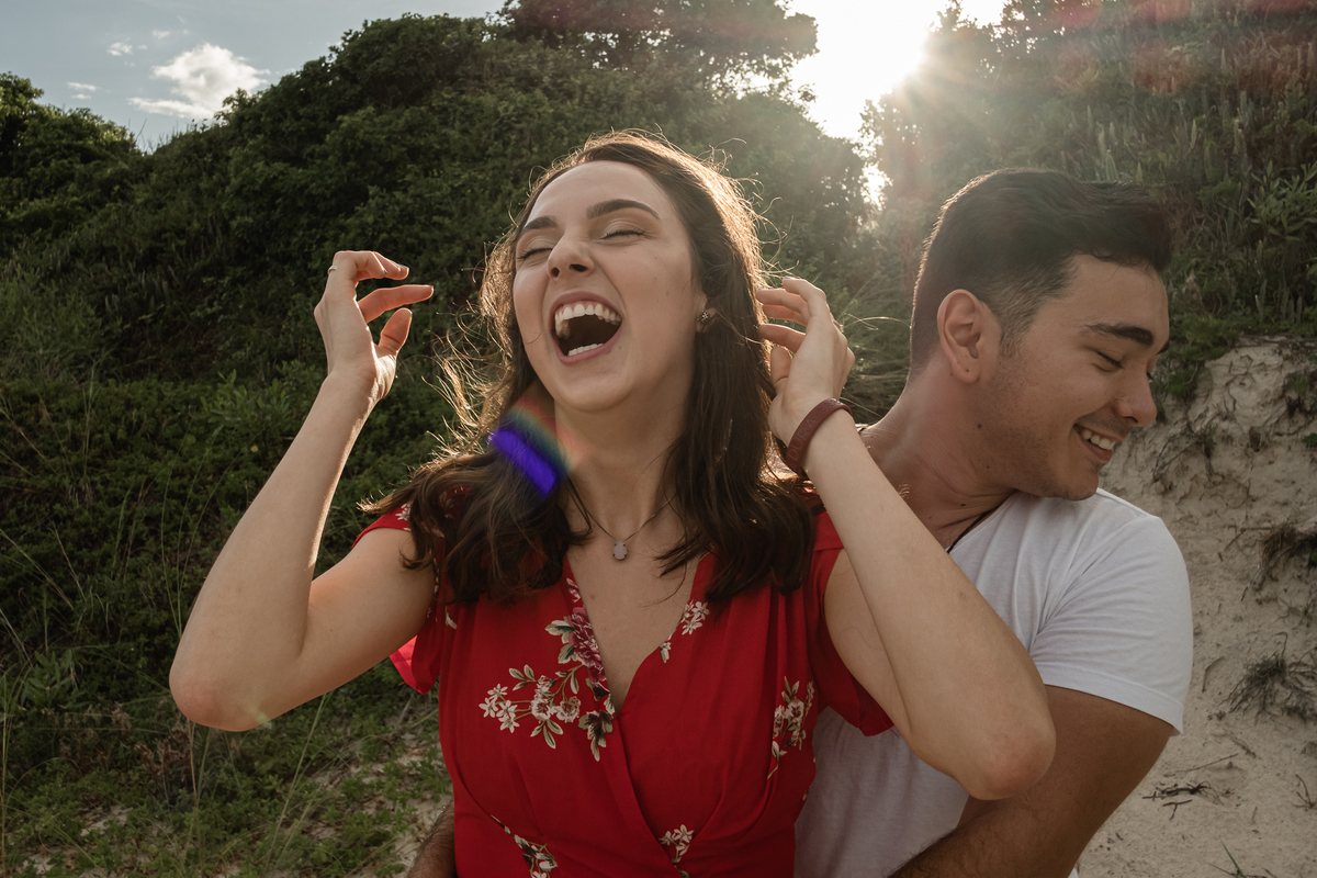 noivos sorrindo no ensaio precasamento na praia