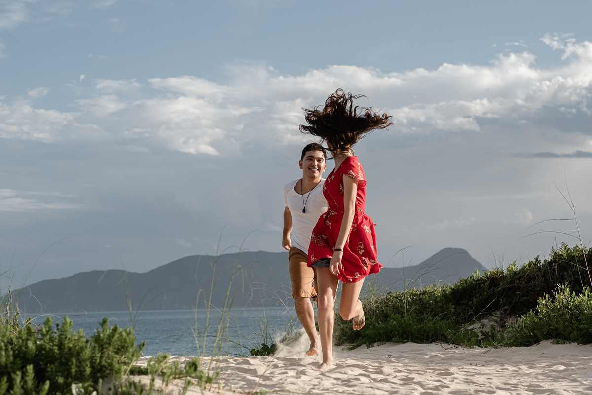 noivos correndo na areia da praia do campeche em floripa no ensaio pré-casamento