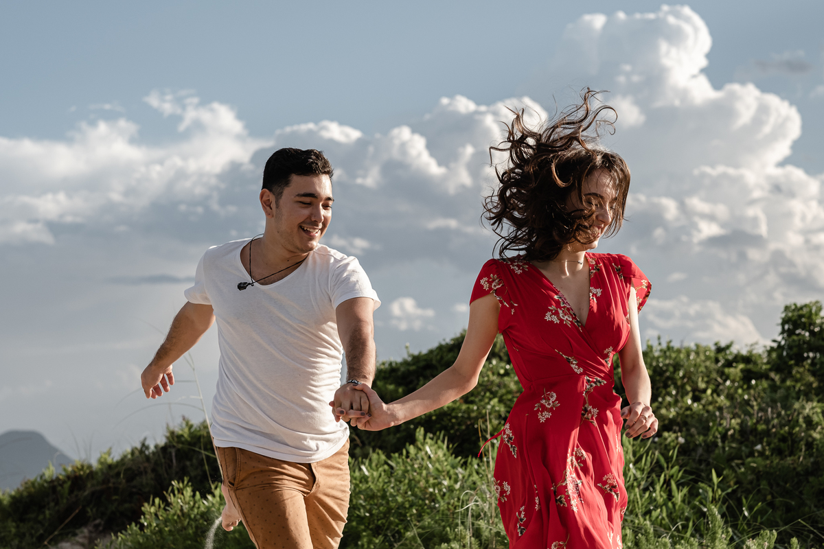 noivos correndo na areia da praia do campeche em floripa no ensaio pré-casamento