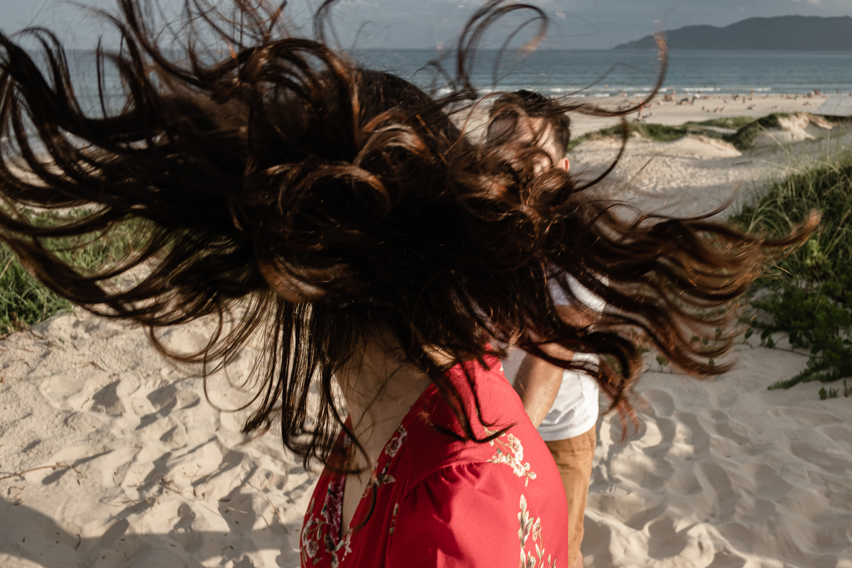 noivos correndo na areia da praia do campeche em floripa no ensaio pré-casamento